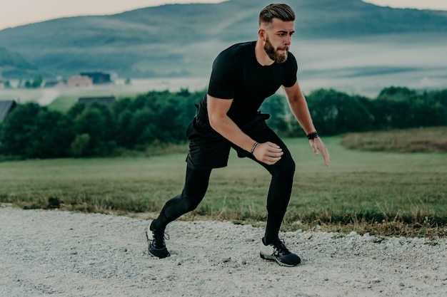 Uomo che corre / sprint su strada in montagna. Montare il corridore di fitness maschile durante l'allenamento all'aperto. Giovane uomo caucasico.