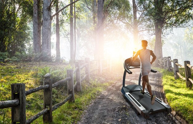 Uomo che corre su un concetto di tapis roulant per esercizio fisico, fitness e stile di vita sano. Tecnica mista