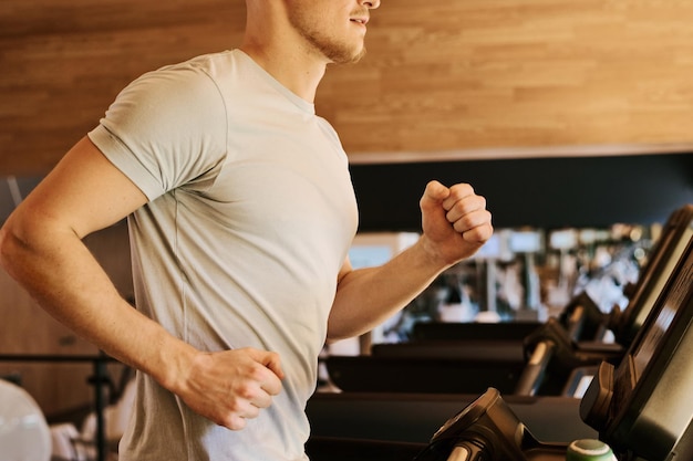 Uomo che corre sul tapis roulant in palestra