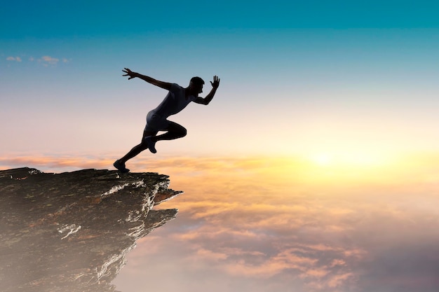 Uomo che corre sullo sfondo del cielo al tramonto