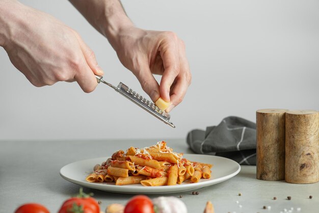 Uomo che cucina formaggio grattugiato