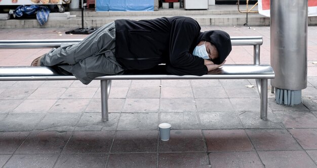 Uomo che dorme sul marciapiede