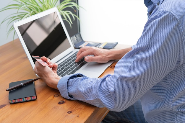 Uomo che effettua pagamenti online davanti al computer.