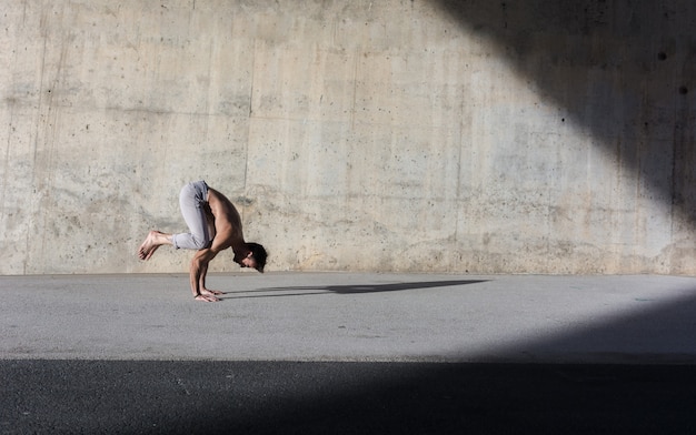 Uomo che esegue esercizi di yoga avanzati e stretching.