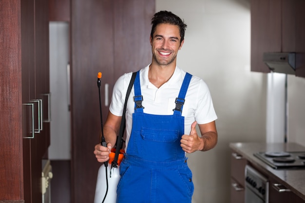 Uomo che fa il controllo dei parassiti in cucina