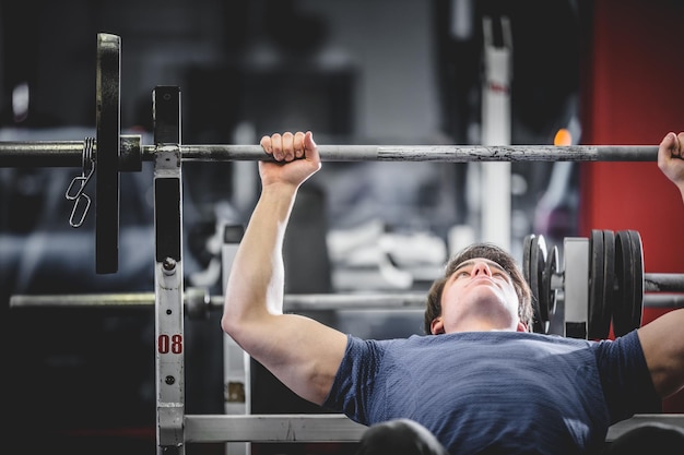 Uomo che fa panca in palestra