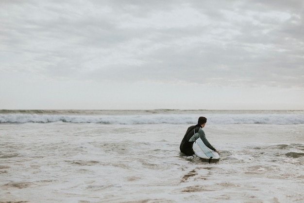 Uomo che fa surf in spiaggia