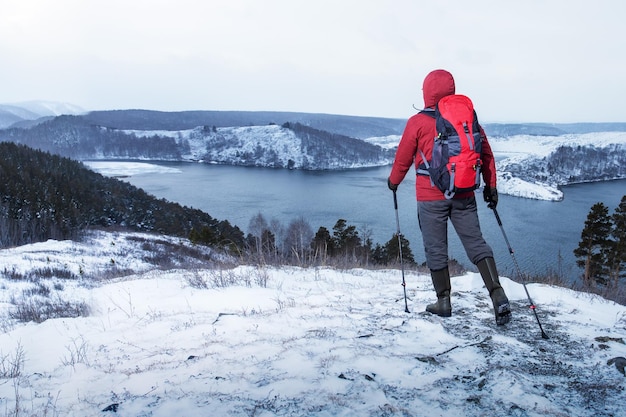 Uomo che fa un'escursione vicino al lago in una giornata invernale Viaggio con stile di vita avventuroso, voglia di viaggiare