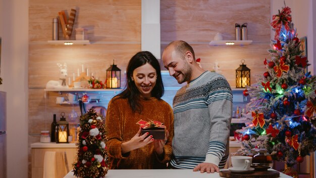 Uomo che fa un regalo alla donna per la festa di Natale