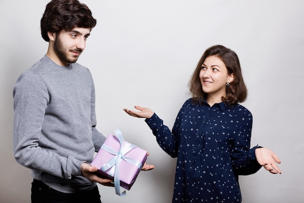 Uomo che fa un regalo alla sua ragazza. Sorpresa romantica, la donna riceve un regalo dal suo ragazzo