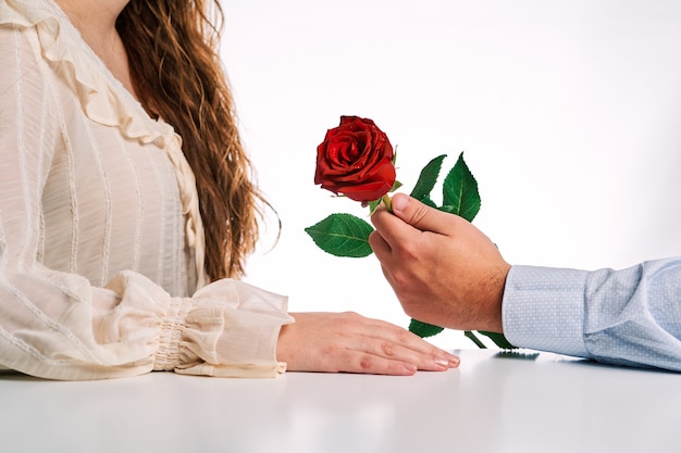 Uomo che fa un regalo di una rosa rossa al suo partner. Concetto di San Valentino, coppia innamorata e matrimonio.