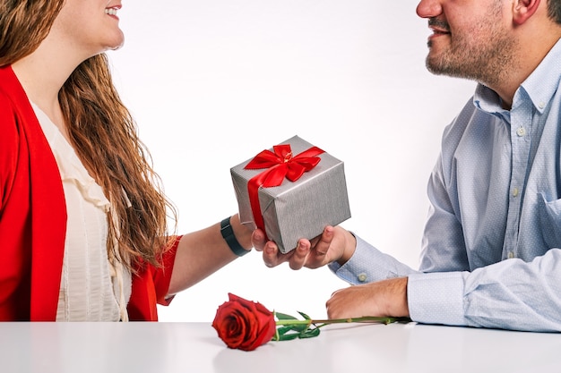 Uomo che fa un regalo e una rosa rossa al suo partner. Concetto di San Valentino e coppia innamorata.