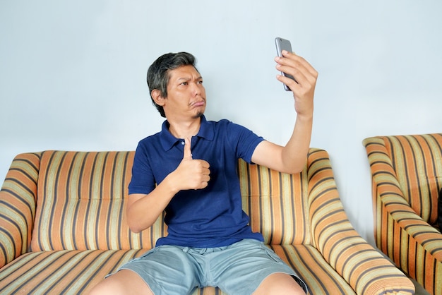 Uomo che fa una videochiamata a casa usando il telefono