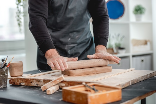 Uomo che forma stampo da argilla ceramica in officina