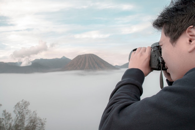 Uomo che fotografa un vulcano in eruzione