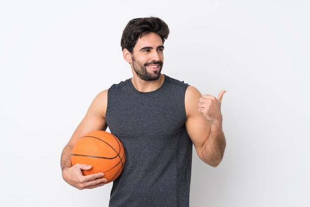 Uomo che gioca a basket sopra la parete isolata