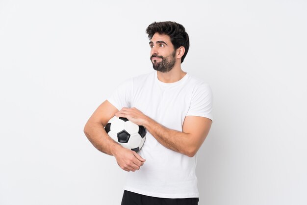 Uomo che gioca a calcio sopra la parete isolata