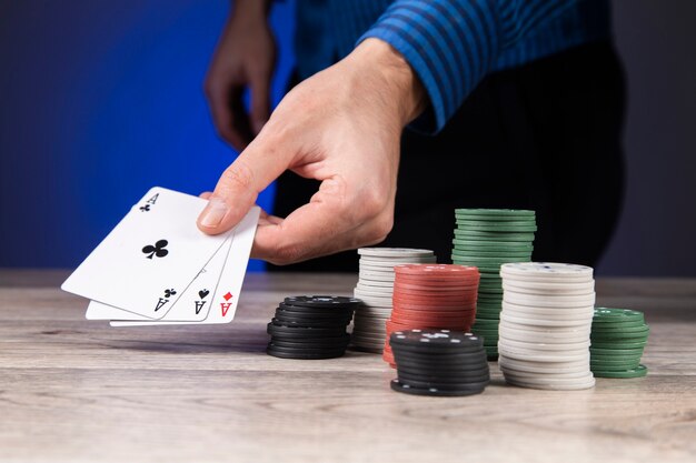 Uomo che gioca a poker e guarda gli assi sul tavolo