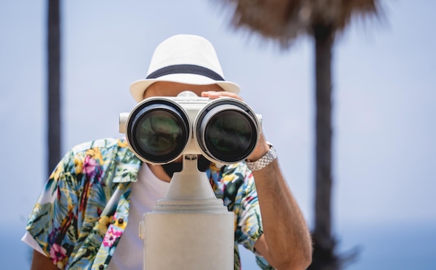 Uomo che guarda attraverso il binocolo in piedi sul punto di osservazione