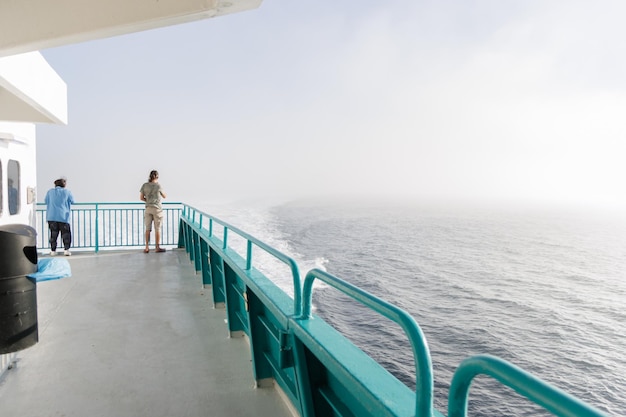 Uomo che guarda il mare dal ponte di un traghetto