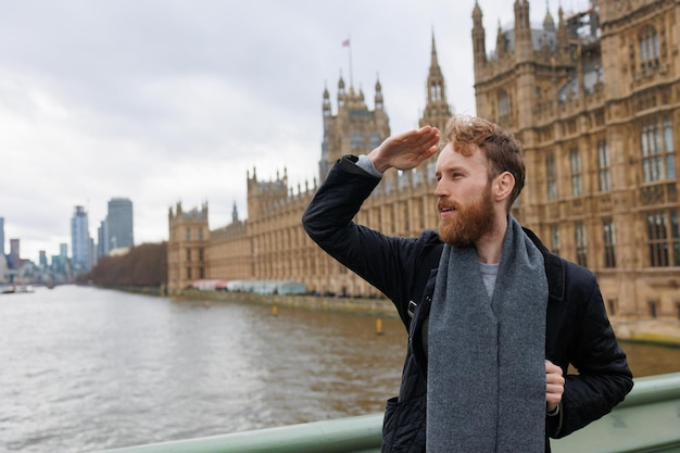 Uomo che guarda in lontananza le attrazioni di Londra