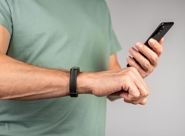 Uomo che guarda l'app fitness tracker al telefono e controlla le metriche di salute dei risultati sportivi Strumento per il monitoraggio dell'attività quotidiana Conteggio del numero di passaggi Monitoraggio della frequenza cardiaca Monitoraggio dei modelli di sonno