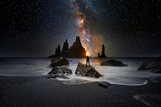 Uomo che guarda l'universo dalla spiaggia