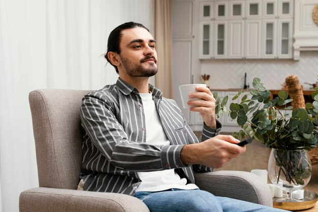 Uomo che guarda la tv e mangia popcorn