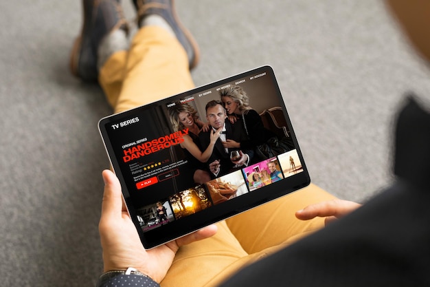 Uomo che guarda serie TV e film tramite il servizio di streaming sul suo tablet digitale