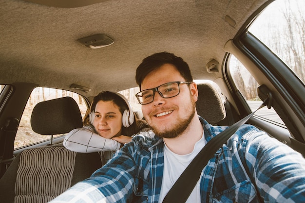 Uomo che guida auto donna seduta come passeggero ai sedili posteriori auto tr