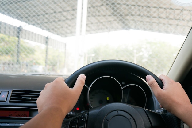 Uomo che guida con entrambe le mani sul volante messa a fuoco selettiva auto guida di sicurezza