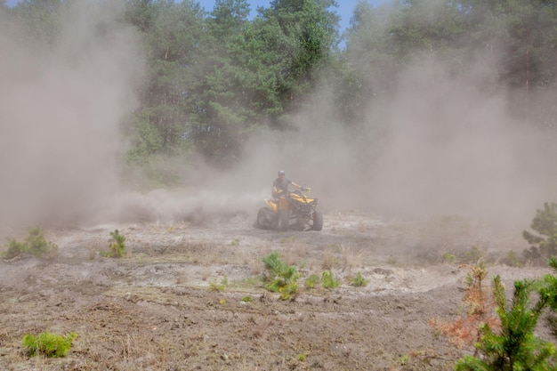 Uomo che guida un veicolo fuoristrada quad giallo ATV su una foresta sabbiosa Attrazione turistica avventura movimento sport estremo