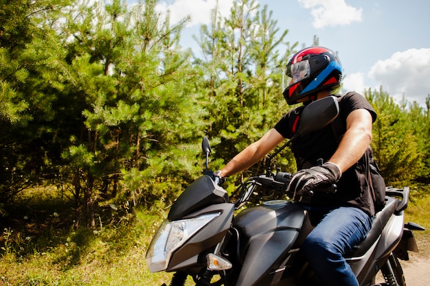 Uomo che guida una moto su strada sterrata con casco