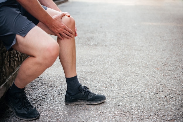 Uomo che ha dolore al ginocchio durante l'esercizio di lesioni sportive concept