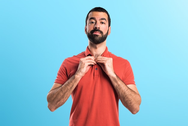 Uomo che indossa camicia di polo rossa su sfondo colorato