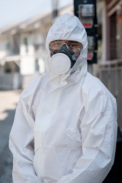 Uomo che indossa guanti con tuta e maschera protettiva chimica a rischio biologico. Con la faccia infelice.