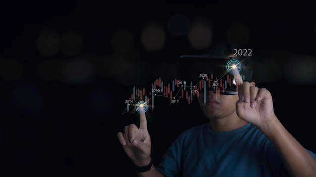 Uomo che indossa l'auricolare VR che mostra la crescita dell'ologramma virtuale del mercato azionario delle statistiche commerciali e l'aumento degli indicatori di crescita positiva degli investimenti azionari finanziari del concetto di metaverso