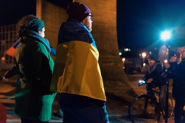 Uomo che indossa la bandiera ucraina in una manifestazione pubblica contro la guerra in Ucraina nella città slovacca di Ruzomberok