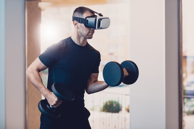 Uomo che indossa occhiali per realtà virtuale con manubri