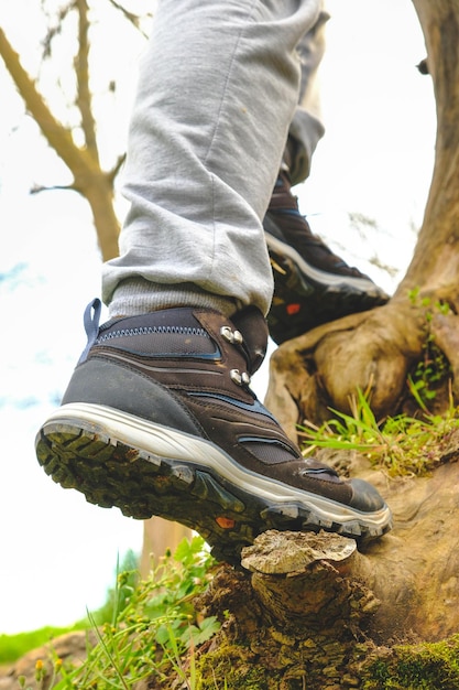 Uomo che indossa scarpe all'aperto nel tema dell'arrampicata e del trekking in natura