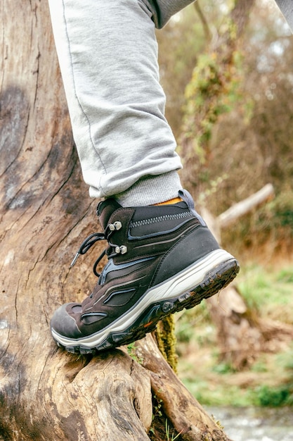 Uomo che indossa scarpe all'aperto nel tema dell'arrampicata e del trekking in natura