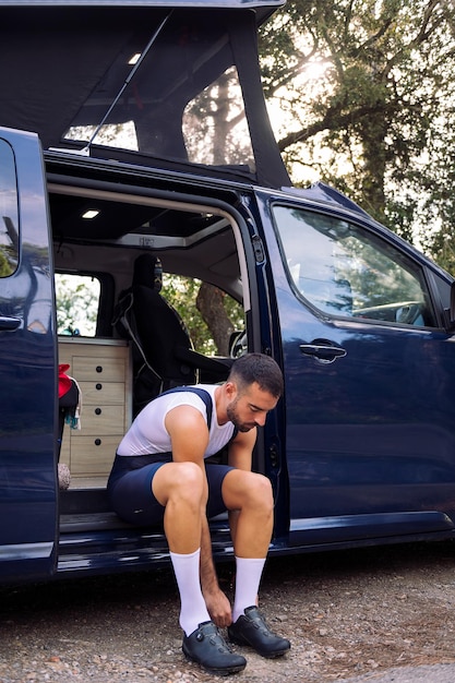 Uomo che indossa scarpe da ciclismo seduto sul suo camper