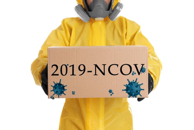 Uomo che indossa tuta protettiva chimica con scatola di cartone su sfondo bianco primo piano Focolaio di coronavirus