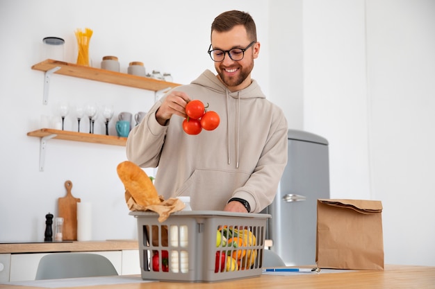 Uomo che ispeziona la sua consegna di generi alimentari