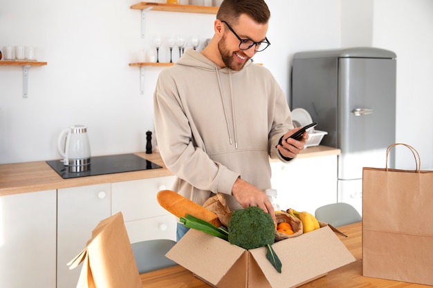 Uomo che ispeziona la sua consegna di generi alimentari