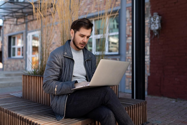 Uomo che lavora al computer portatile fuori online