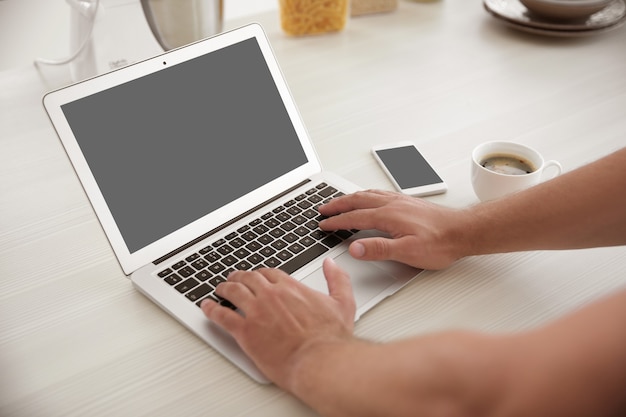 Uomo che lavora al laptop e beve caffè