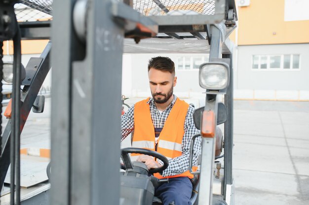 Uomo che lavora al magazzino e guida il carrello elevatore