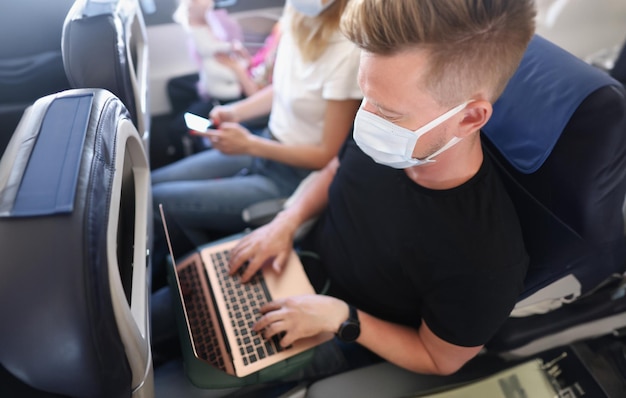 Uomo che lavora all'aria aperta, dispositivo portatile, maschera per il viso, protezione, freelance occupato in volo.