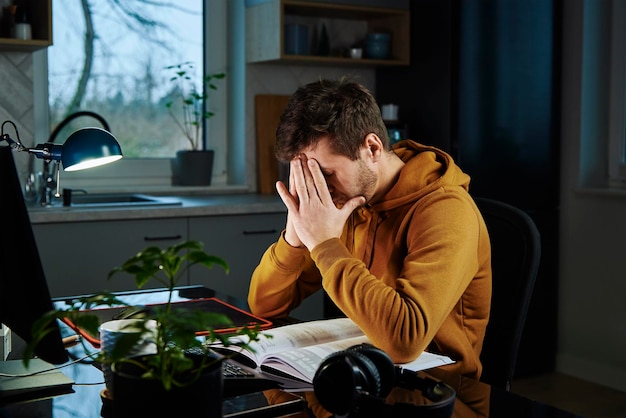 Uomo che lavora fino a tardi da remoto a casa